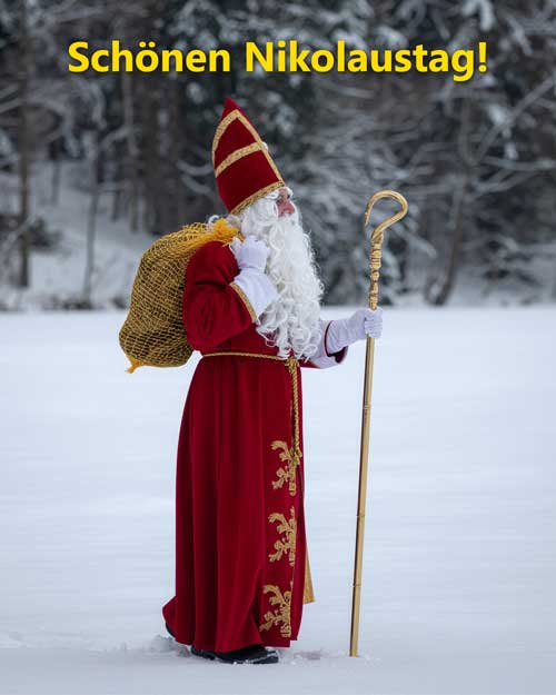 Nikolaus mit einem Sack Kartoffeln. Der Nikolaus geht über eine verschneite Wiese. Er trägt ein traditionelles rotes Gewand, hat einen langen weißen Bart. In der einen Hand hat er seinen Stab. Mit der anderen Hand trägt er einen Sack Kartoffeln auf dem Rücken. Das Bild wurde KI generiert.